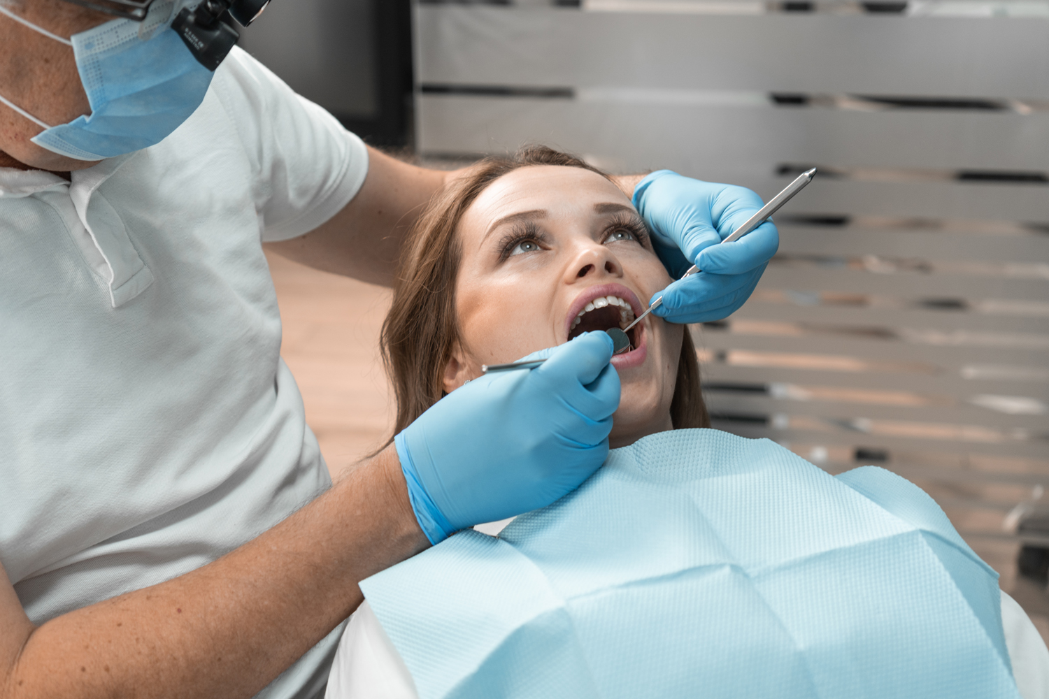 The dentist in clinic conducts professional treatment patient's teeth using advanced methods and technologies. Her attention to detail and specialized skills ensure effective and painless treatment.